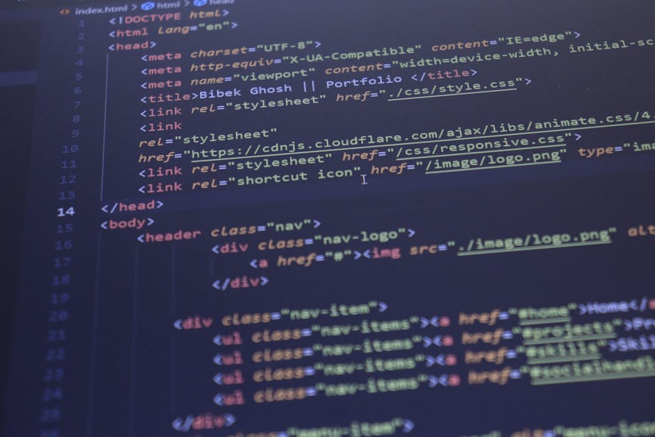 A close-up photograph of a computer screen displaying lines of code in a code editor. The code includes HTML tags with a mix of blue, yellow, red, and white text on a dark background. Specific element